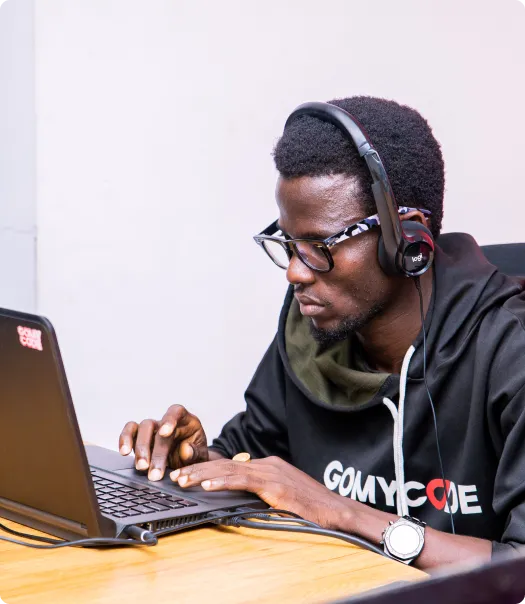 Homme assis devant son ordinateur avec un casque sur les oreilles pour la formation python