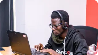 Homme assis devant son ordinateur avec un casque sur les oreilles pour la formation python