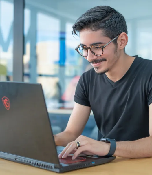 Homme à lunettes assis devant son ordinateur pour l'introduction à la cybersécurité