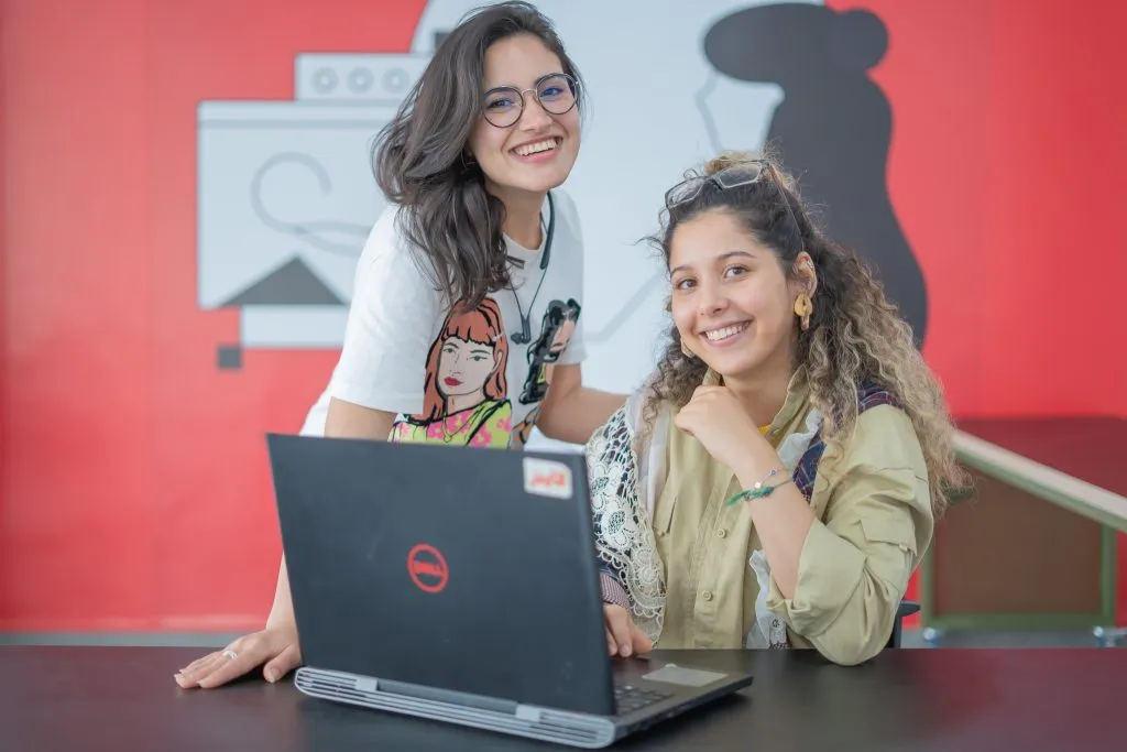 Deux femmes souriantes sur un PC pour le cours