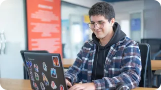 Homme souriant devant son ordinateur pour l'introduction au développement de jeu vidéo